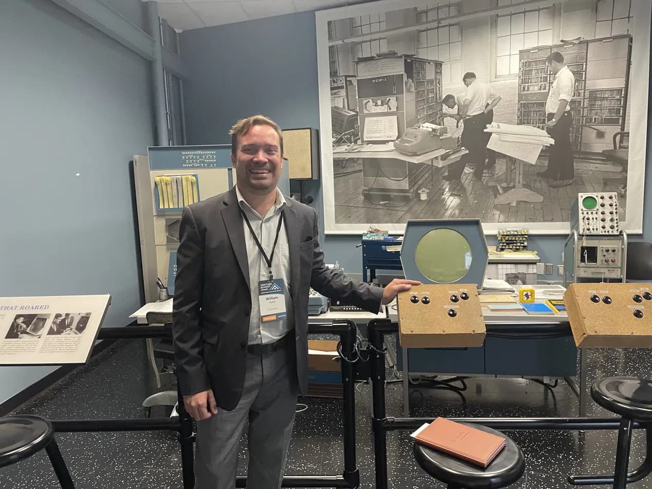 Dr. William Hahn at Venture Summit, standing beside a historic computer exhibit